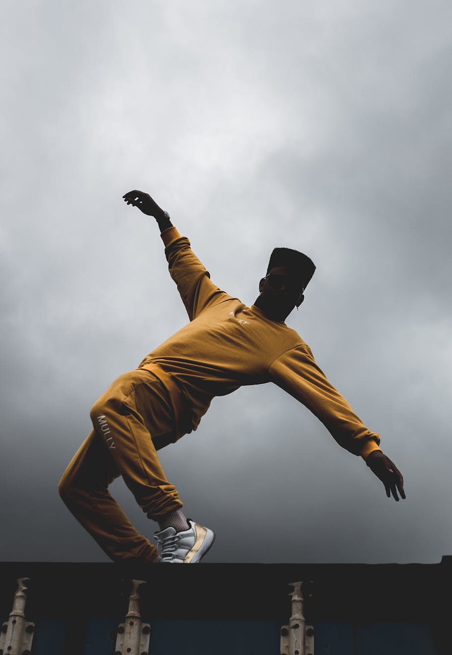 Silhouette of an athlete stretching against a dark, moody background.
